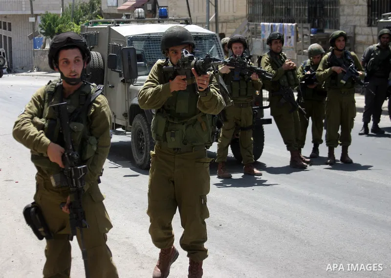 Israeli soldiers take position during a demonstration by Palestinian, Israeli, and foreign protesters in the West Bank village of Beit Omar, near Hebron Friday, July 22, 2011. The demonstration concerned a recent video r...