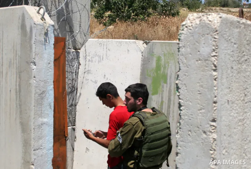 An Israeli soldier detains a protester during a demonstration by Palestinian, Israeli, and foreign protesters in the West Bank village of Beit Omar, near Hebron Friday, July 22, 2011. The demonstration concerned a recent...