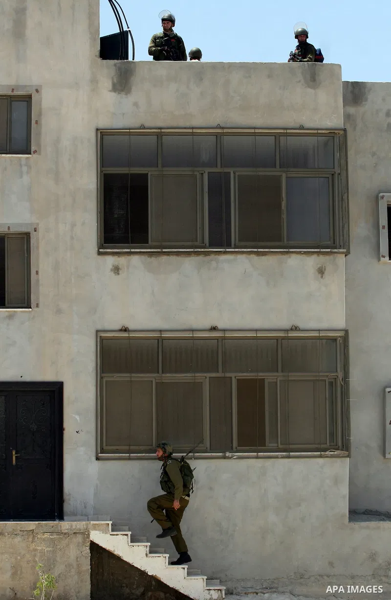 Israeli soldiers take positions during clashes with Palestinian protesters from the West Bank village of Nabi Saleh, north of Ramallah, on July 22, 2011 during a weekly Friday protest against Israeli West Bank settlement...