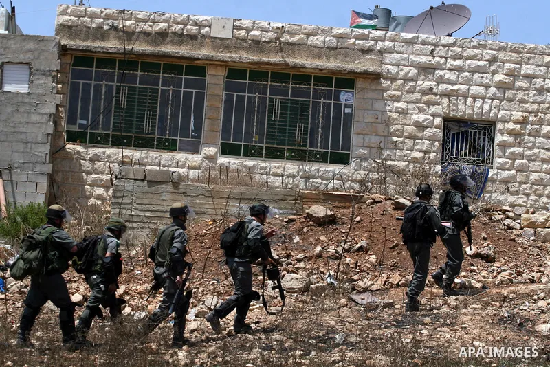 Israeli soldiers take positions during clashes with Palestinian protesters from the West Bank village of Nabi Saleh, north of Ramallah, on July 22, 2011 during a weekly Friday protest against Israeli West Bank settlement...