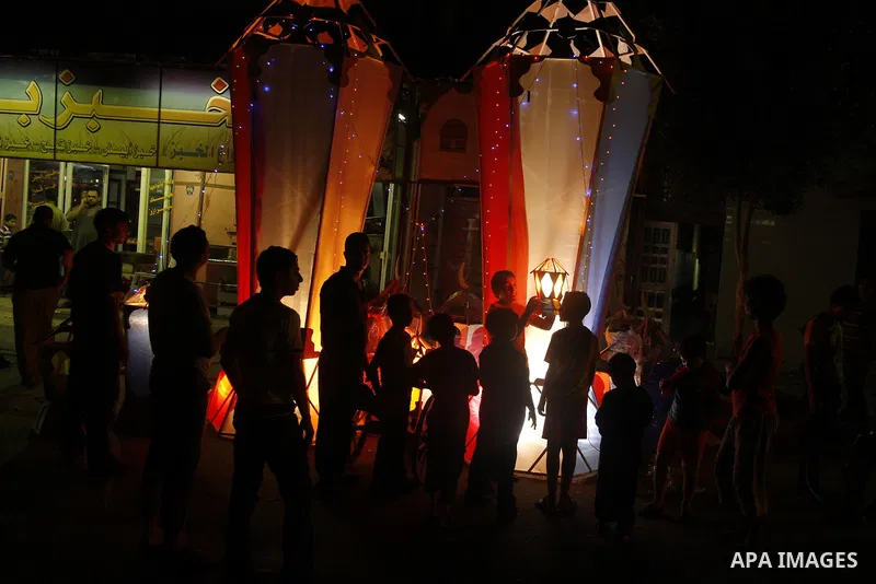 Palestinian children gather around a giant paper lantern, traditionally used as decoration during the Muslim holy month of Ramadan, in Gaza City on July 23, 2011. Photo by Mahmud Nassar