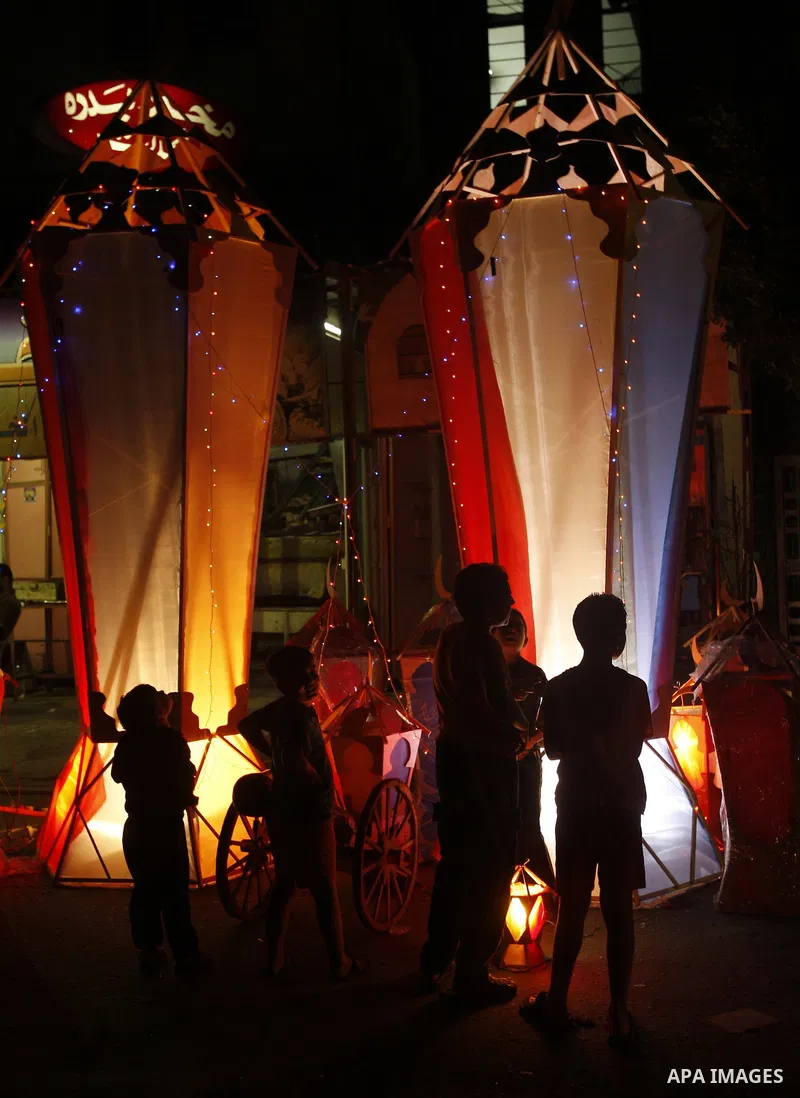Palestinian children gather around a giant paper lantern, traditionally used as decoration during the Muslim holy month of Ramadan, in Gaza City on July 23, 2011. Photo by Mahmud Nassar