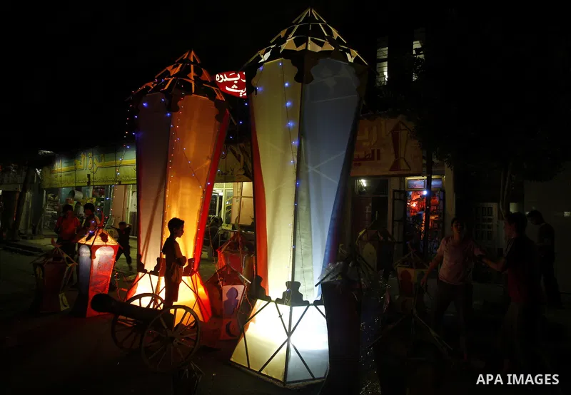 Palestinian children gather around a giant paper lantern, traditionally used as decoration during the Muslim holy month of Ramadan, in Gaza City on July 23, 2011. Photo by Mahmud Nassar