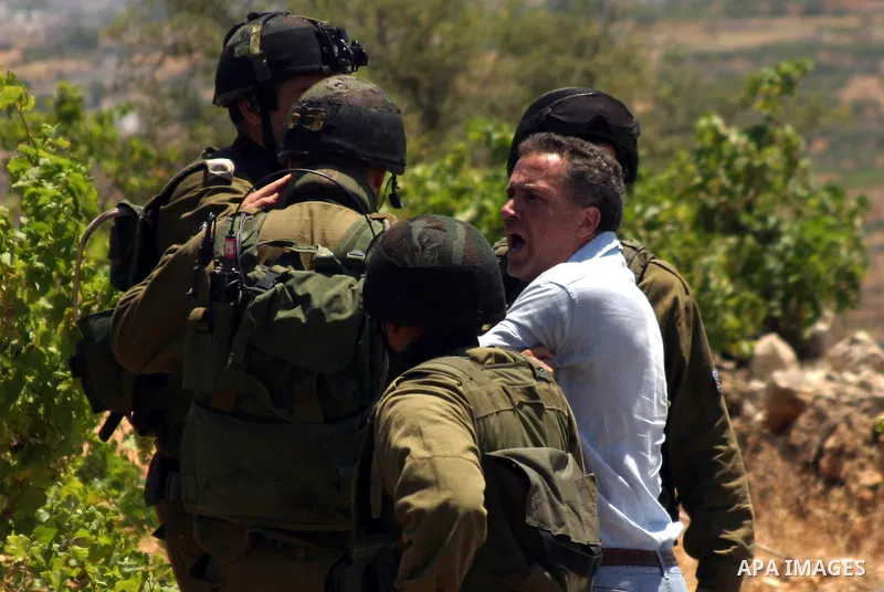 An Israeli soldier detains a protester during a demonstration against Israel's controversial separation barrier in the West Bank village of Beit Omar, near Hebron, 23 July 2011. Israel says the network of steel and concr...