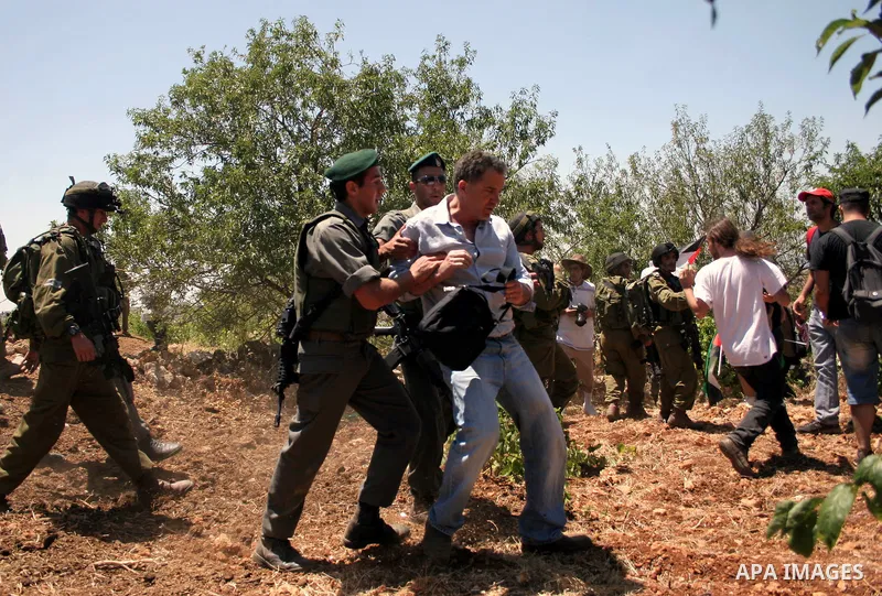 An Israeli soldier detains a protester during a demonstration against Israel's controversial separation barrier in the West Bank village of Beit Omar, near Hebron, 23 July 2011. Israel says the network of steel and concr...