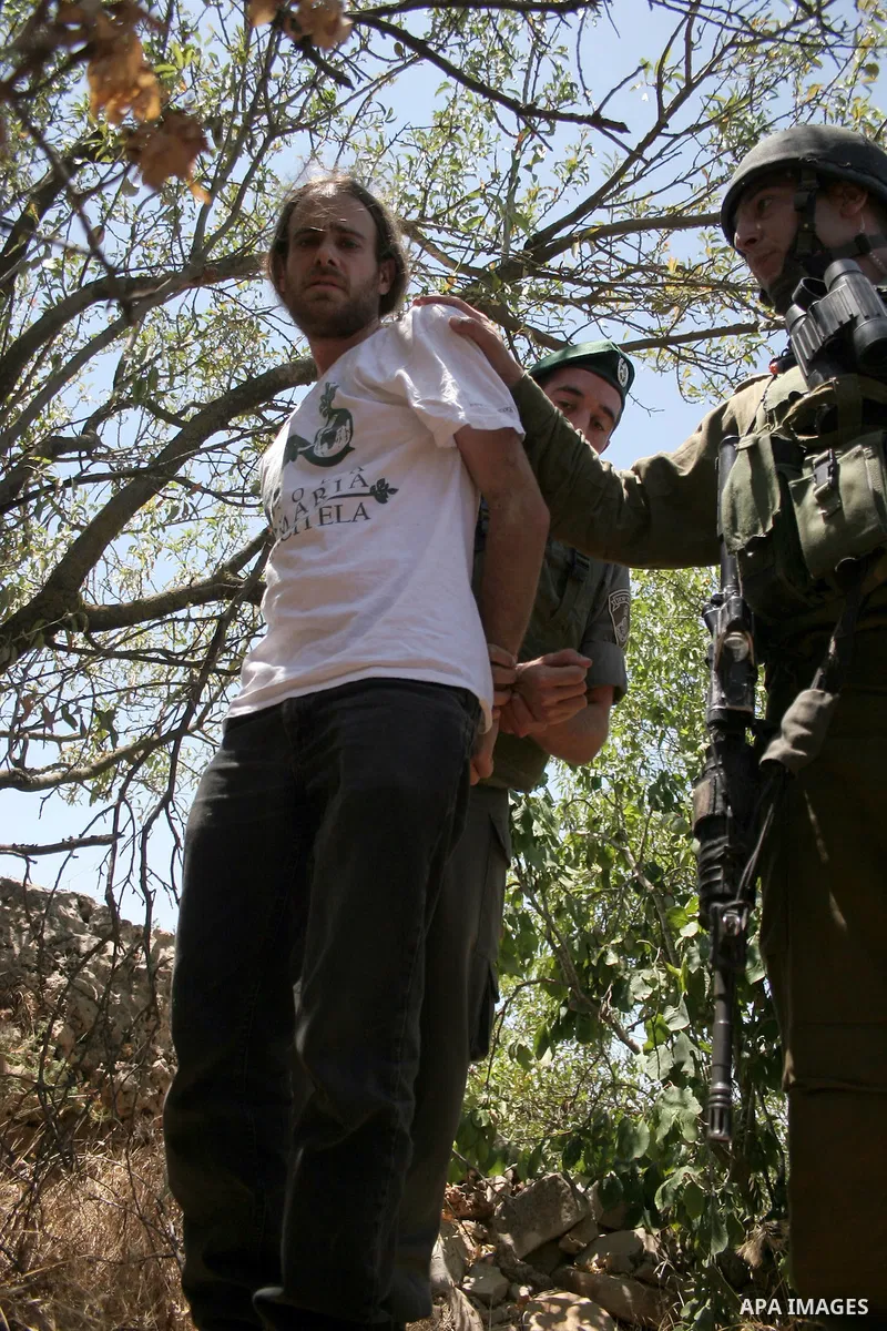 An Israeli soldier detains a protester during a demonstration against Israel's controversial separation barrier in the West Bank village of Beit Omar, near Hebron, 23 July 2011. Israel says the network of steel and concr...