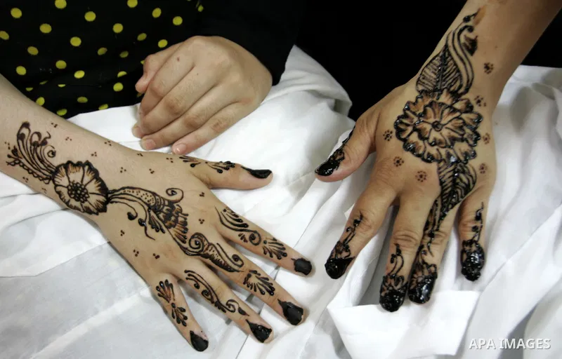 A Palestinian woman applies henna on the hand of a girl during a summer camp organised by the Ministry of Youth and Sports in Rafah, southern Gaza Strip, on July 23, 2011. Photo by Abed Rahim Khatib