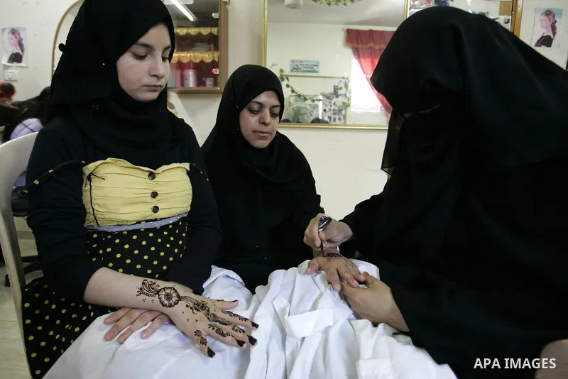 A Palestinian woman applies henna on the hand of a girl during a summer camp organised by the Ministry of Youth and Sports in Rafah, southern Gaza Strip, on July 23, 2011. Photo by Abed Rahim Khatib