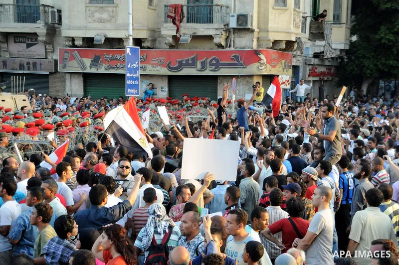 Egyptian soldiers stand guard behind barbed wire as protesters demonstrate outside the defence ministry, the headquarters of the Supreme Council of the Armed Forces, in Cairo on July 23, 2011 to show their anger at the r...