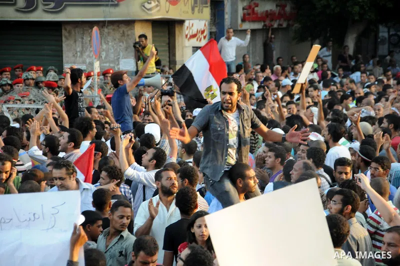 Egyptian soldiers stand guard behind barbed wire as protesters demonstrate outside the defence ministry, the headquarters of the Supreme Council of the Armed Forces, in Cairo on July 23, 2011 to show their anger at the r...