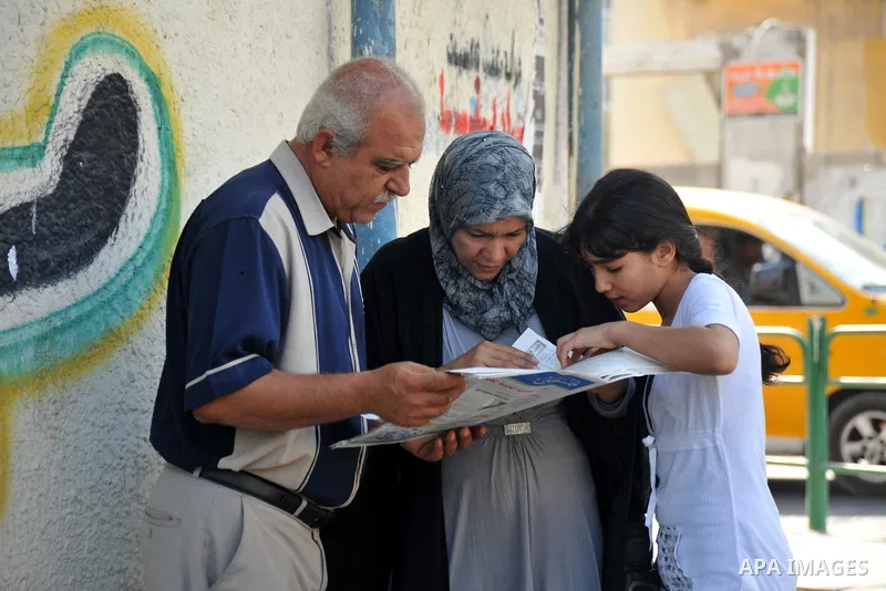 Palestinian relatives of secondary school students read a local newspaper to find their results in Gaza city on July 24,2011. The Ministry of Education in Gaza Strip and the West Bank announced the results together. Phot...