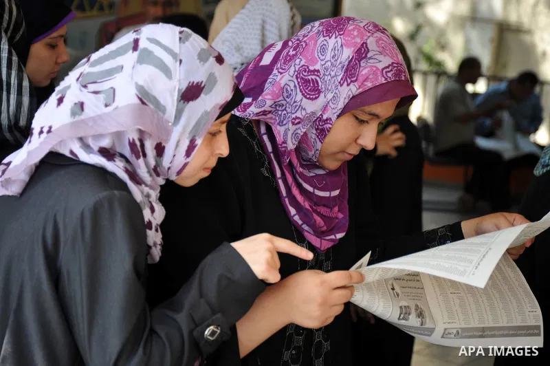 Palestinian secondary school students read a local newspaper to find their results in Gaza city on July 24,2011. The Ministry of Education in Gaza Strip and the West Bank announced the results together. Photo by Majdi Fa...