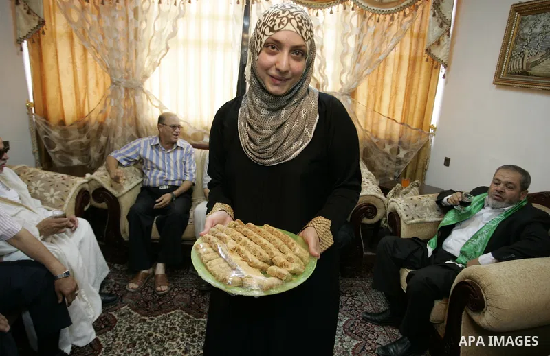 Hadeel Jamal Jaber, a Palestinian secondary school student and the winner of the fourth level in Palestine distributes sweets to her family in Gaza city on July 24, 2011.. Photo by Abed Rahim Khatib