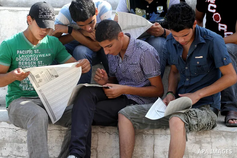 Palestinian secondary school students read a local newspaper to find their results in Gaza city on July 24,2011. The Ministry of Education in Gaza Strip and the West Bank announced the results together. Photo by Mohammed...