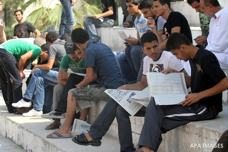 Palestinian secondary school students read a local newspaper to find their results in Gaza city on July 24,2011. The Ministry of Education in Gaza Strip and the West Bank announced the results together. Photo by Mohammed...
