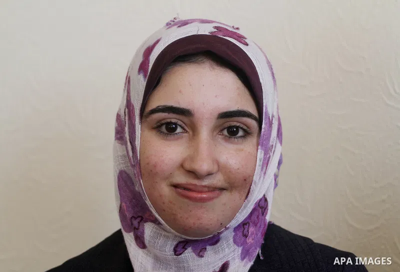 A Palestinian secondary school student and the first in section literary, Asmaa` Al-Sahhar celebrates with her family after hear her result in Gaza city on July 24,2011. The Ministry of Education in Gaza Strip and the We...