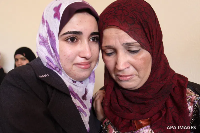 A Palestinian secondary school student and the first in section literary, Asmaa` Al-Sahhar, cries with joy and celebrating with her mother after hear her result in Gaza city on July 24,2011. The Ministry of Education in...