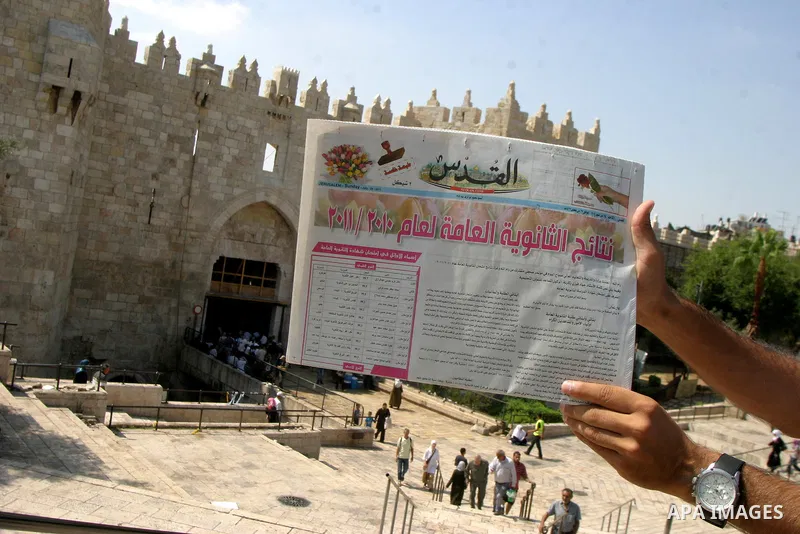 Palestinian students read a local newspaper as they look for their results of final high school exams, known as "Tawjihi" in Jerusalem's old city on July 24,2011.. Photo by Mahfouz Abu Turk