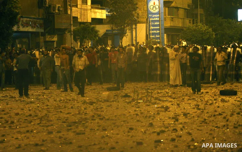 Demonstrators throw rocks during clashes with loyalists of the ruling military council in Abbasiya district, where the army blocked the road leading to the defence ministry, the headquarters of the Supreme Council of the...