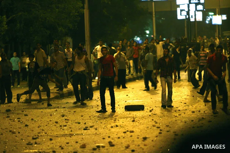 Demonstrators throw rocks during clashes with loyalists of the ruling military council in Abbasiya district, where the army blocked the road leading to the defence ministry, the headquarters of the Supreme Council of the...
