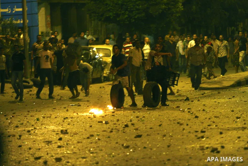 Demonstrators throw rocks during clashes with loyalists of the ruling military council in Abbasiya district, where the army blocked the road leading to the defence ministry, the headquarters of the Supreme Council of the...