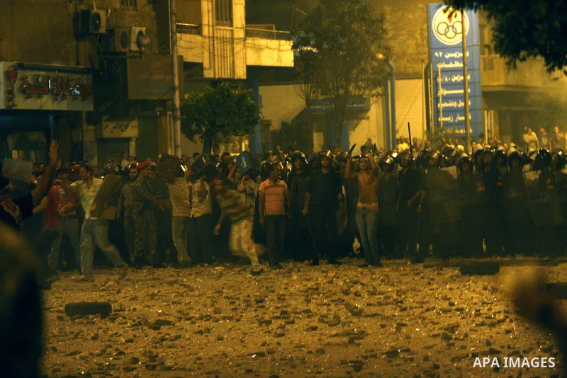 Demonstrators throw rocks during clashes with loyalists of the ruling military council in Abbasiya district, where the army blocked the road leading to the defence ministry, the headquarters of the Supreme Council of the...