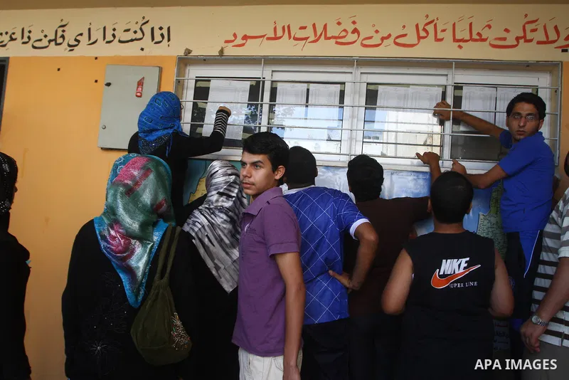 Palestinian secondary school students read a local newspaper to find their results in Gaza city on July 24,2011. The Ministry of Education in Gaza Strip and the West Bank announced the results together. Photo by Ashraf a...