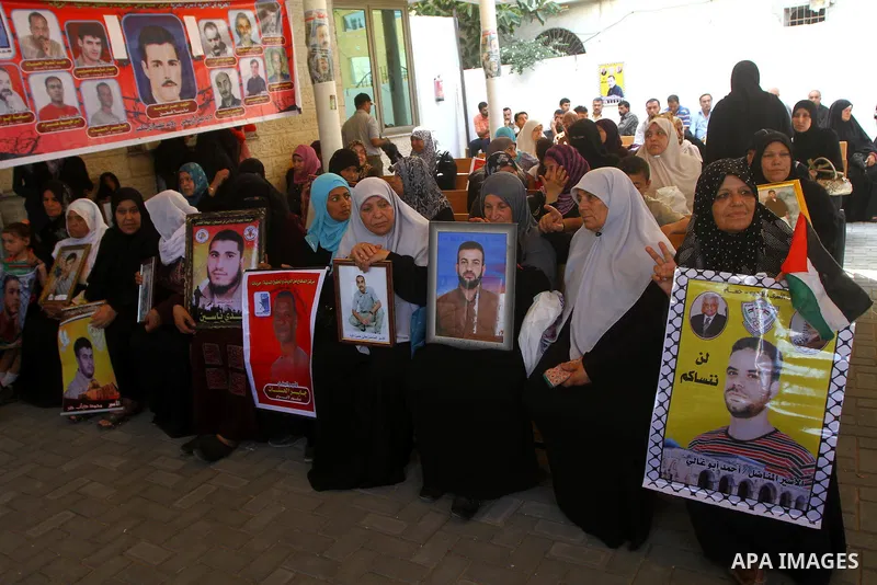 Palestinians women hold pictures of their prisoned relatives in Israeli jails as they gather in a weekly activity calling for their liberty at the Red Cross headquarters in Gaza City on July 25, 2011. About 7000 prisoner...