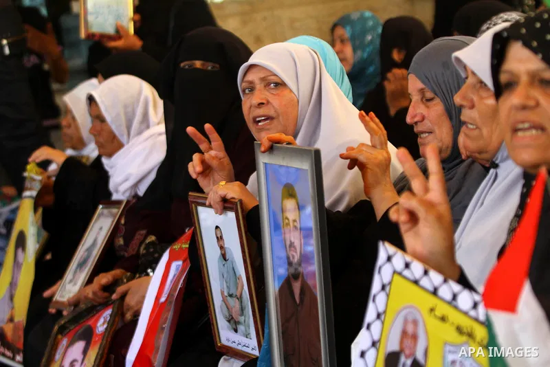 Palestinians women hold pictures of their prisoned relatives in Israeli jails as they gather in a weekly activity calling for their liberty at the Red Cross headquarters in Gaza City on July 25, 2011. About 7000 prisoner...