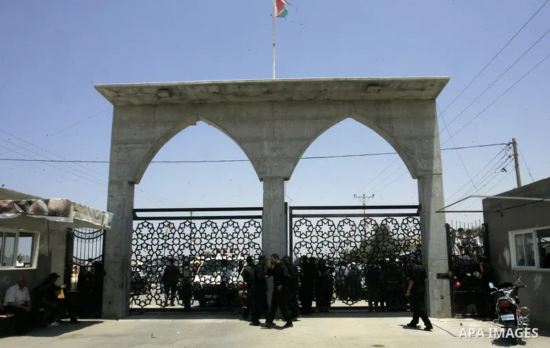 Palestinians stand behind the iron gate of the Rafah border waiting to cross the Rafah border crossing with Egypt, in the southern Gaza Strip on July 25, 2011. Photo by Abed Rahim Khatib