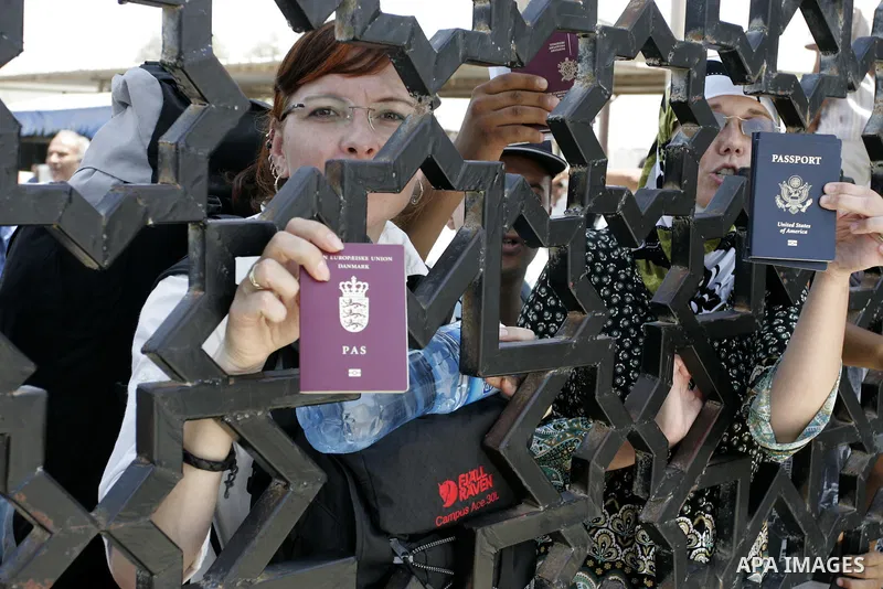 Palestinians stand behind the iron gate of the Rafah border waiting to cross the Rafah border crossing with Egypt, in the southern Gaza Strip on July 25, 2011. Photo by Abed Rahim Khatib