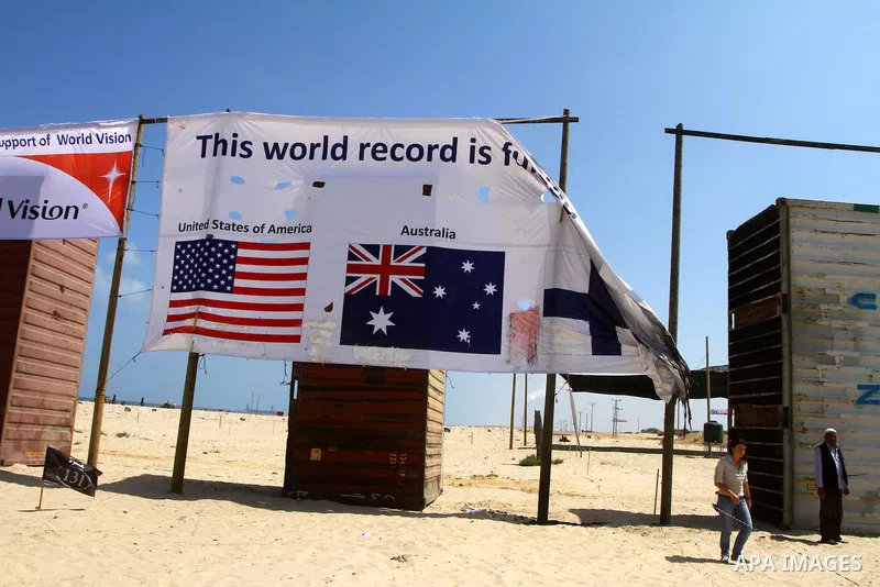 A UN employee inspects burnt billboard at a summer camp in northern Gaza City, on July 28, 2011. Unknown individuals attacked on Thursday a summer camp for schoolchildren sponsored by United Nations Relief and Work Agenc...