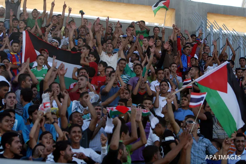 Fans wave Palestinian flags as they cheer during the 2014 FIFA World Cup qualification soccer match between Thailand and the Palestinian Territories at A-Ram stadium near Jerusalem July 28, 2011 Photo by Issam Rimawi