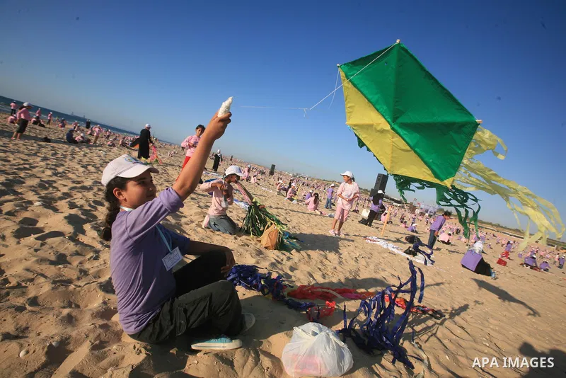 Palestinian children fly kites during an event organized by the United Nations Relief and Works Agency (UNRWA), as they seek to achieve a world record for flying kites, in the northern Gaza Strip, Thursday, July 28, 2011...