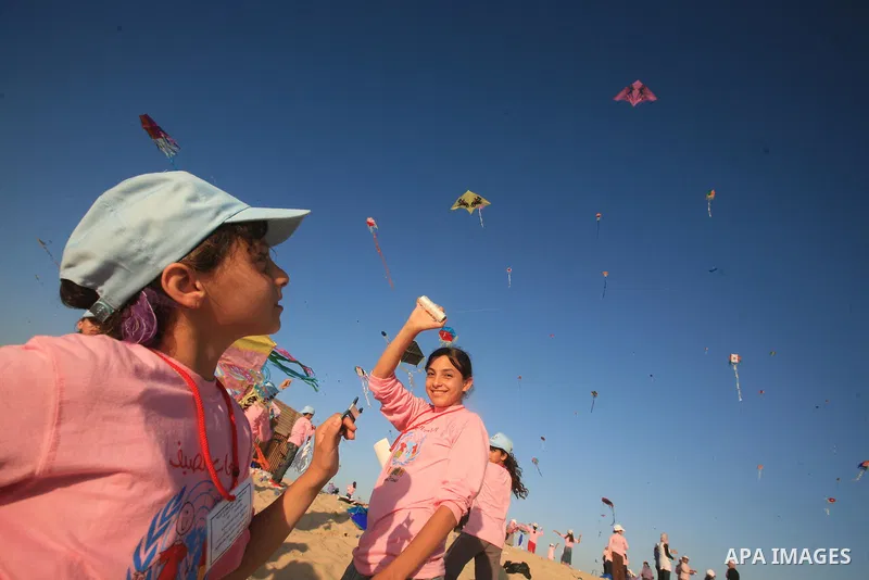 Palestinian children fly kites during an event organized by the United Nations Relief and Works Agency (UNRWA), as they seek to achieve a world record for flying kites, in the northern Gaza Strip, Thursday, July 28, 2011...