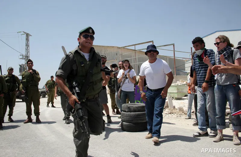 Protesters argue with an Israeli soldiers during a demonstration against Israel's controversial separation barrier in the West Bank village of Maasarah, near the biblical town of Bethlehem on 29 July 2011. Israel says th...