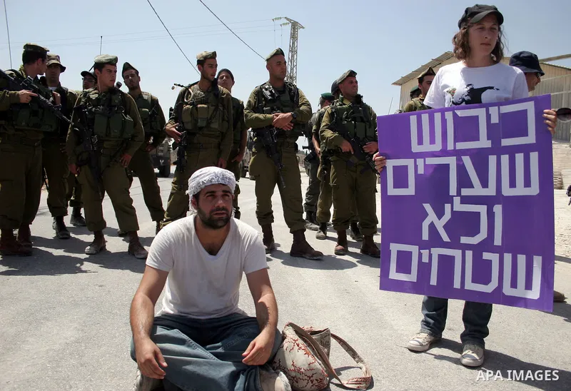 Protesters argue with an Israeli soldiers during a demonstration against Israel's controversial separation barrier in the West Bank village of Maasarah, near the biblical town of Bethlehem on 29 July 2011. Israel says th...