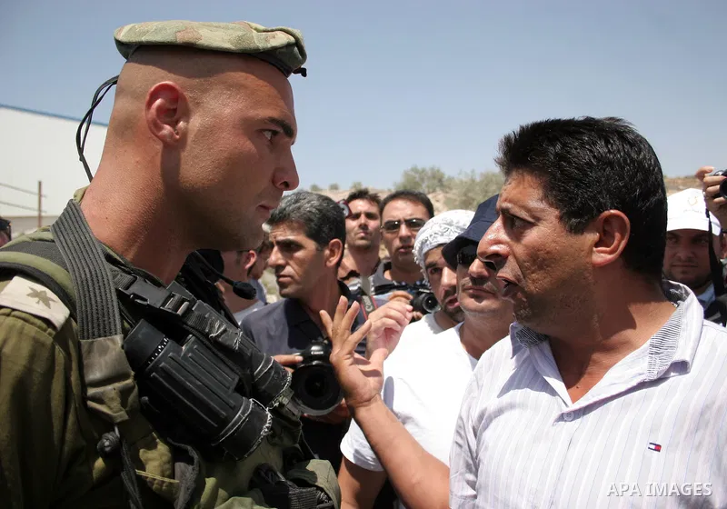 Protesters argue with an Israeli soldiers during a demonstration against Israel's controversial separation barrier in the West Bank village of Maasarah, near the biblical town of Bethlehem on 29 July 2011. Israel says th...