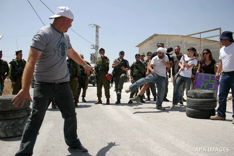 Protesters argue with an Israeli soldiers during a demonstration against Israel's controversial separation barrier in the West Bank village of Maasarah, near the biblical town of Bethlehem on 29 July 2011. Israel says th...