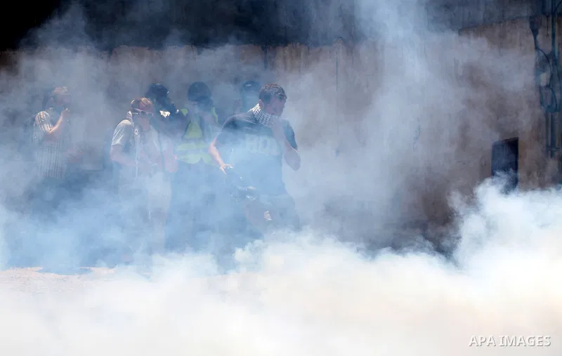 Pro-Palestinian protesters run away from tear gas fired by Israeli security force officers during clashes at a weekly protest in the West Bank village of Nabi Saleh, near Ramallah July 29, 2011. Photo by Issam Rimawi