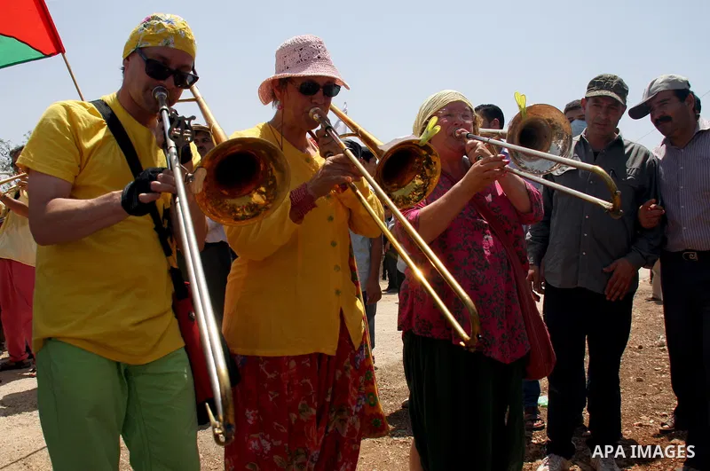 Holland artists from the Dutch street band sing ,during a protest about Palestinian access to lands in the area, in the village of Kufr Qaddum near the Israeli settlement of Kdumim, in the northern West Bank Friday, July...