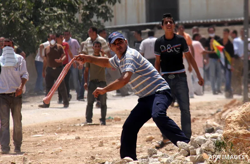 Palestinian youths hurl stones at Israeli security forces, during a protest about Palestinian access to lands in the area, in the village of Kufr Qaddum near the Israeli settlement of Kdumim, in the northern West Bank Fr...
