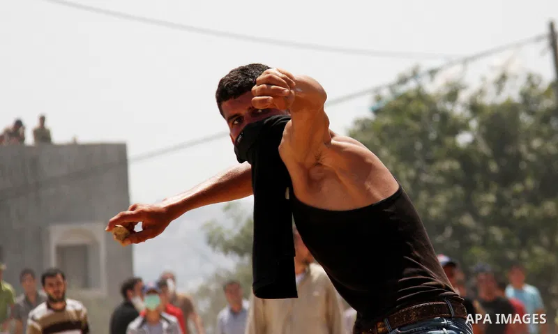 Palestinian youths hurl stones at Israeli security forces, during a protest about Palestinian access to lands in the area, in the village of Kufr Qaddum near the Israeli settlement of Kdumim, in the northern West Bank Fr...
