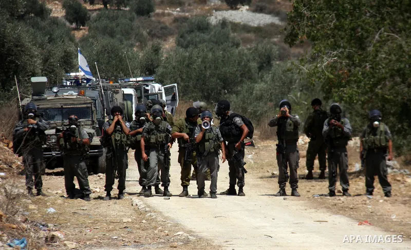 Israeli soldiers take positions during a protest about Palestinian access to lands in the area, in the village of Kufr Qaddum near the Israeli settlement of Kdumim, in the northern West Bank Friday, July 29, 2011. Photo...