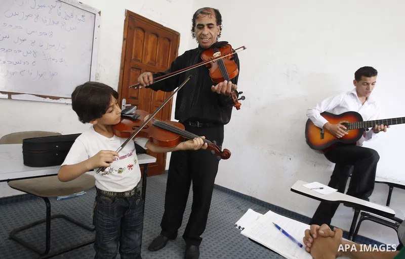 A Palestinian boy plays on musical instruments at the Gaza College in the Department of Music in Gaza city on July 30, 2011. Photo by Mahmud Nassar