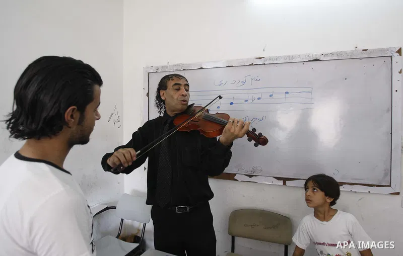 A Palestinian Music teacher during teaching students on on musical instruments at the Gaza College in the Department of Music in Gaza city on July 30, 2011. Photo by Mahmud Nassar