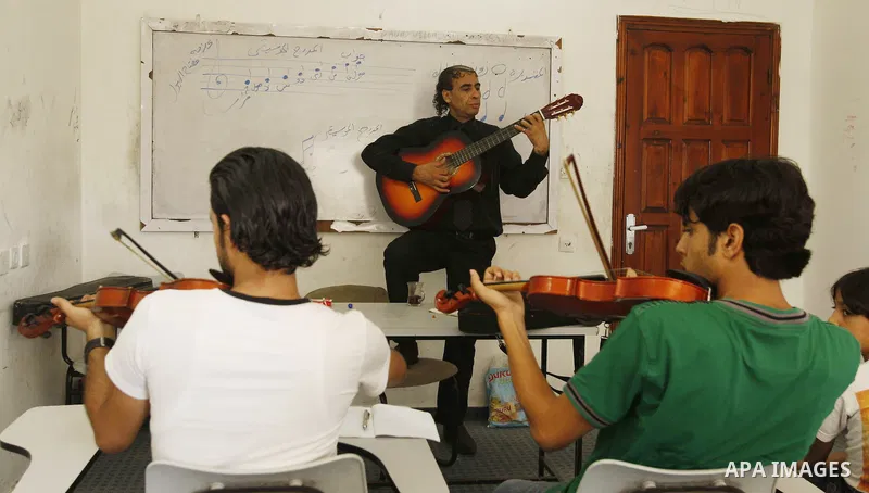 A Palestinian Music teacher during teaching students on on musical instruments at the Gaza College in the Department of Music in Gaza city on July 30, 2011. Photo by Mahmud Nassar