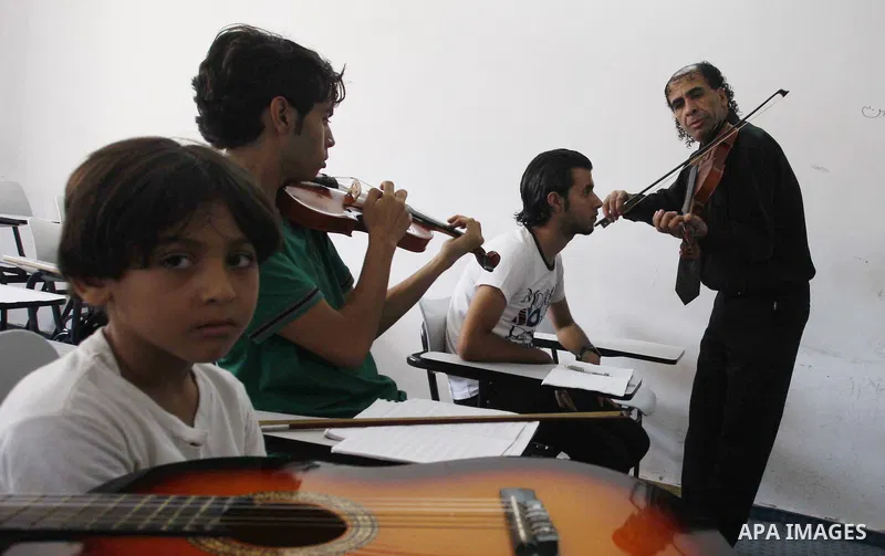 A Palestinian boy plays on musical instruments at the Gaza College in the Department of Music in Gaza city on July 30, 2011. Photo by Mahmud Nassar