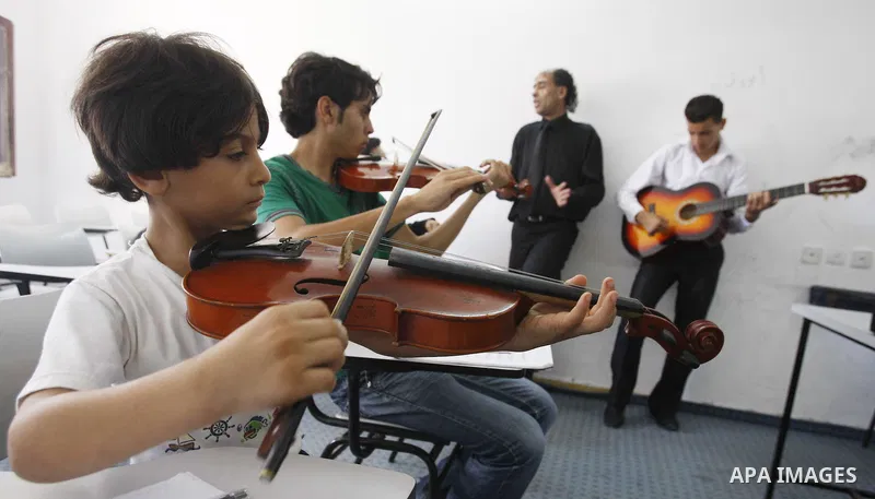 A Palestinian boy plays on musical instruments at the Gaza College in the Department of Music in Gaza city on July 30, 2011. Photo by Mahmud Nassar