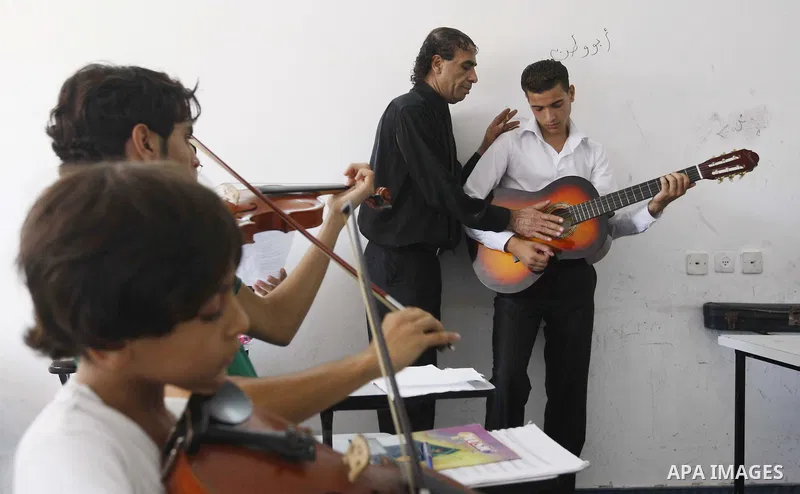 A Palestinian boy plays on musical instruments at the Gaza College in the Department of Music in Gaza city on July 30, 2011. Photo by Mahmud Nassar